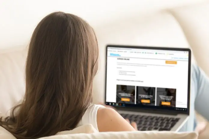 Woman using laptop on comfortable sofa at home