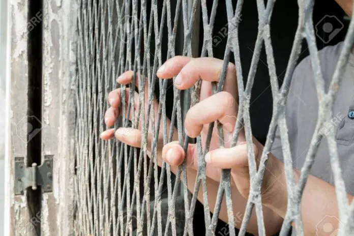 Hands of the woman on a steel lattice