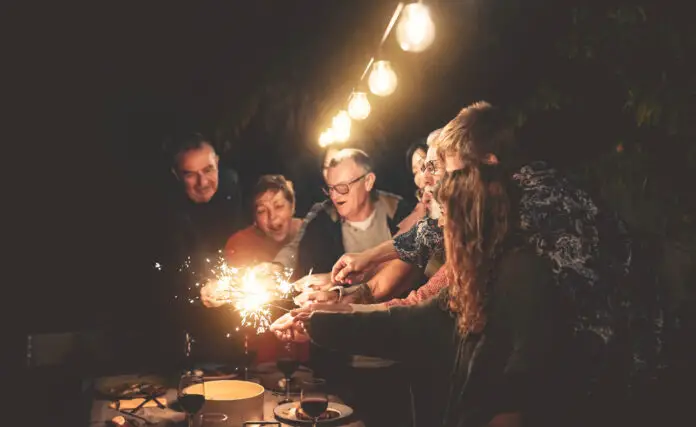 Happy family having fun at dinner night party outdoor - Group of