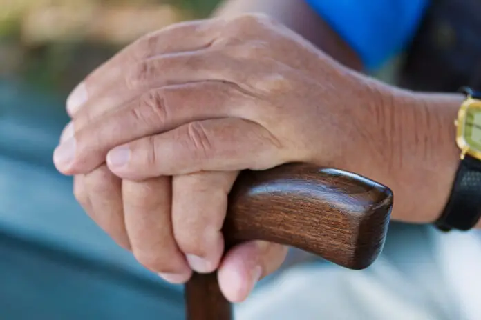Hand eines Mannes mit Gehstock